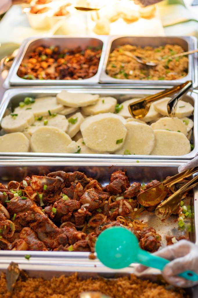 Buffet of jollof rice, peppered meat and pounded yam